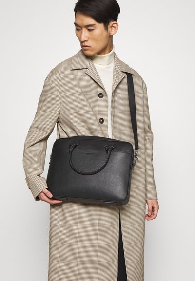 Black leather laptop bag with top handles and a detachable shoulder strap, featuring a smooth texture and minimalist design.