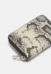 Kompaktowy portfel z białej i czarnej skóry w nadruk wężowy, z teksturowanym wykończeniem oraz metalowym zamkiem błyskawicznym z uchwytem.