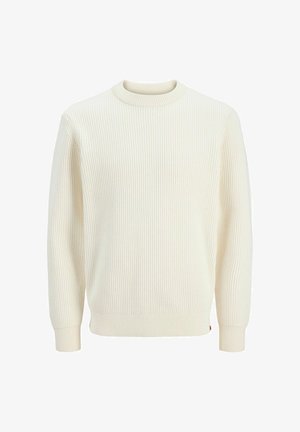 Kreemist ribikangast sviiter, millel on ümar kaelus, pikad varrukad ja elastsed mansetid. Kanga tekstuur on reljeefne ja veidi veniv.