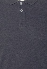 Polo shirt blu navy realizzato in morbido tessuto a maglia, con colletto classico, tre bottoni argentati e una finitura testurizzata.