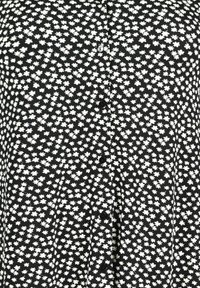 Black fabric featuring a white floral pattern, button front closure, and short sleeves. Texture appears smooth with a lightweight design.