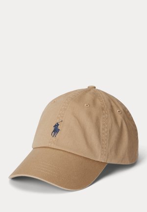 Jasnobrązowa czapka bejsbolowa z przyszytymi otworami wentylacyjnymi i małym, ciemnoniebieskim, haftowanym logo gracza polo na przednim środku.