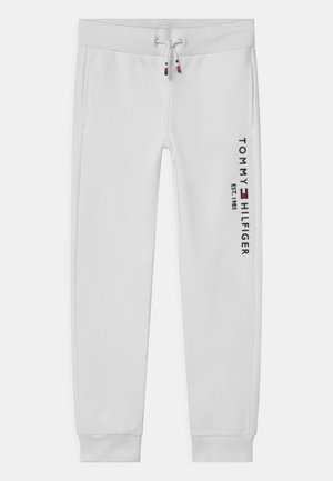 Białe spodnie dresowe wykonane z miękkiego materiału, z elastycznym pasem ze sznurkami, bocznymi kieszeniami oraz nadrukowanym logo na lewej nogawce.