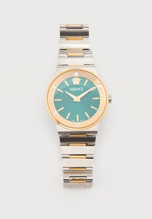 Montre-bracelet Versace avec cadran vert, lunette dorée, index dorés et bracelet métallique bicolore en argent et or.