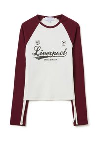 Langarmshirt met een witte romp en bordeauxrode raglanmouwen. Beschikt over een pailletten "Liverpool" graphic en zij-trekkoordjes.