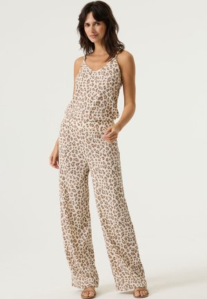 Jumpsuit mit Leopardenmuster in hellbeigen Tönen, mit V-Ausschnitt, dünnen Trägern und weitem Bein. Hergestellt aus leichtem, strukturiertem Stoff.