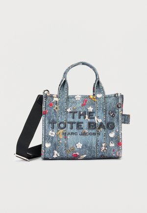 Kokvilnas soma ar melnu siksnu, dekorēta ar krāsainiem izšūtiem simboliem un tekstu "THE TOTE BAG ARC JACOBS" priekšpusē.