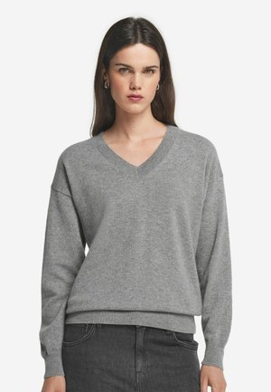 Maglione grigio a collo a V con maniche lunghe, polsini e orlo a coste, realizzato in un materiale morbido, caratterizzato da una vestibilità comoda e un design minimalista.
