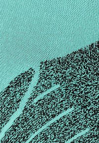 Zbliżenie na teksturowany materiał w odcieniu turkusowym z ciemnym, skomplikowanym wzorem przypominającym abstrakcyjne fale lub linie.