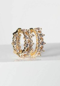 Guldörhängen i form av hoopen med en rad av klara ovala och runda ädelstenar, med en lagerdesign och en glänsande yta.