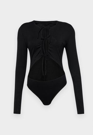 Fekete, hosszú ujjú body, kerek nyakkal, kivágott oldalakkal és állítható elülső kötelekkel. Simogató, rugalmas anyagból készült.