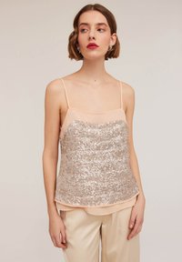 Ärmelloses Oberteil mit einer durchsichtigen, pfirsichfarbenen Oberlage und einem goldenen Pailletten-Unterteil mit Chevron-Muster, glattem Stoff und lockerer Passform.