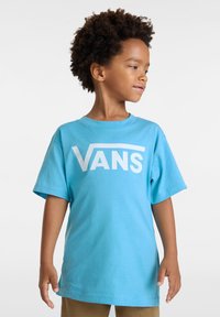 Světle modré tričko s krátkým rukávem vyrobené z měkké bavlny, s velkým bílým logem "VANS" vytištěným na přední straně. Standardní střih.