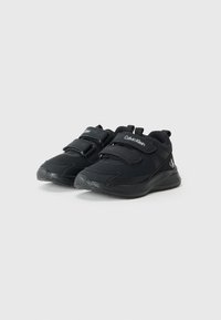 Chaussures de sport noires avec une tige en synthétique, deux bandes Velcro et une semelle en caoutchouc texturé. Logo de la marque affiché en blanc.