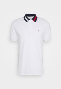 Bílá polo košile se límečkem v námořnické modré a červené pruhy. Na levém prsu je malé logo. Vyrobeno z bavlny. Krátké rukávy.