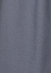 Miękka, gładka szara tkanina o delikatnej diagonalnej fakturze splotu, z łagodnymi fałdami tworzącymi różnice światła i cienia.