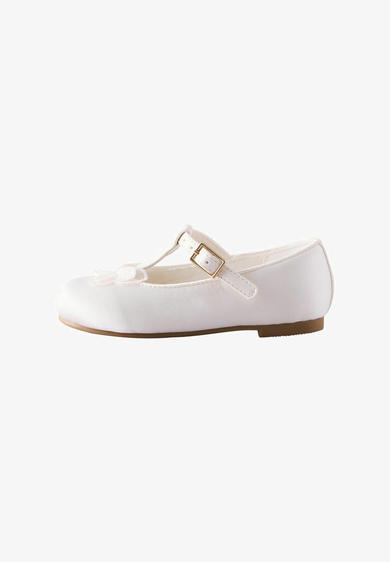 Chaussure plate blanche avec un bout arrondi, design en T, boucle ajustable et accent floral à l'avant. Fini lisse et satiné.