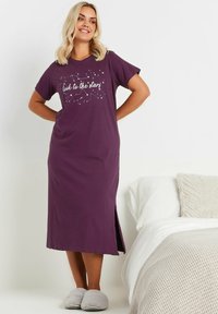 Lila bomullsnattklänning med korta ärmar, prydd med texten "titta mot stjärnorna" och en stjärn grafik, knäslits, i kombination med grå fluffiga tofflor.