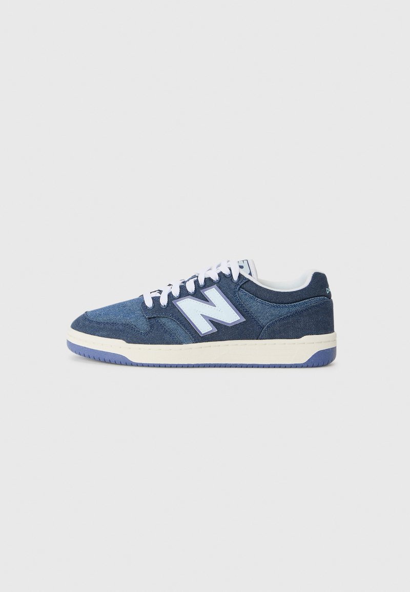Denim sneakers in dark blue with white laces and light blue branding. Features a textured upper and a contrasting cream midsole.