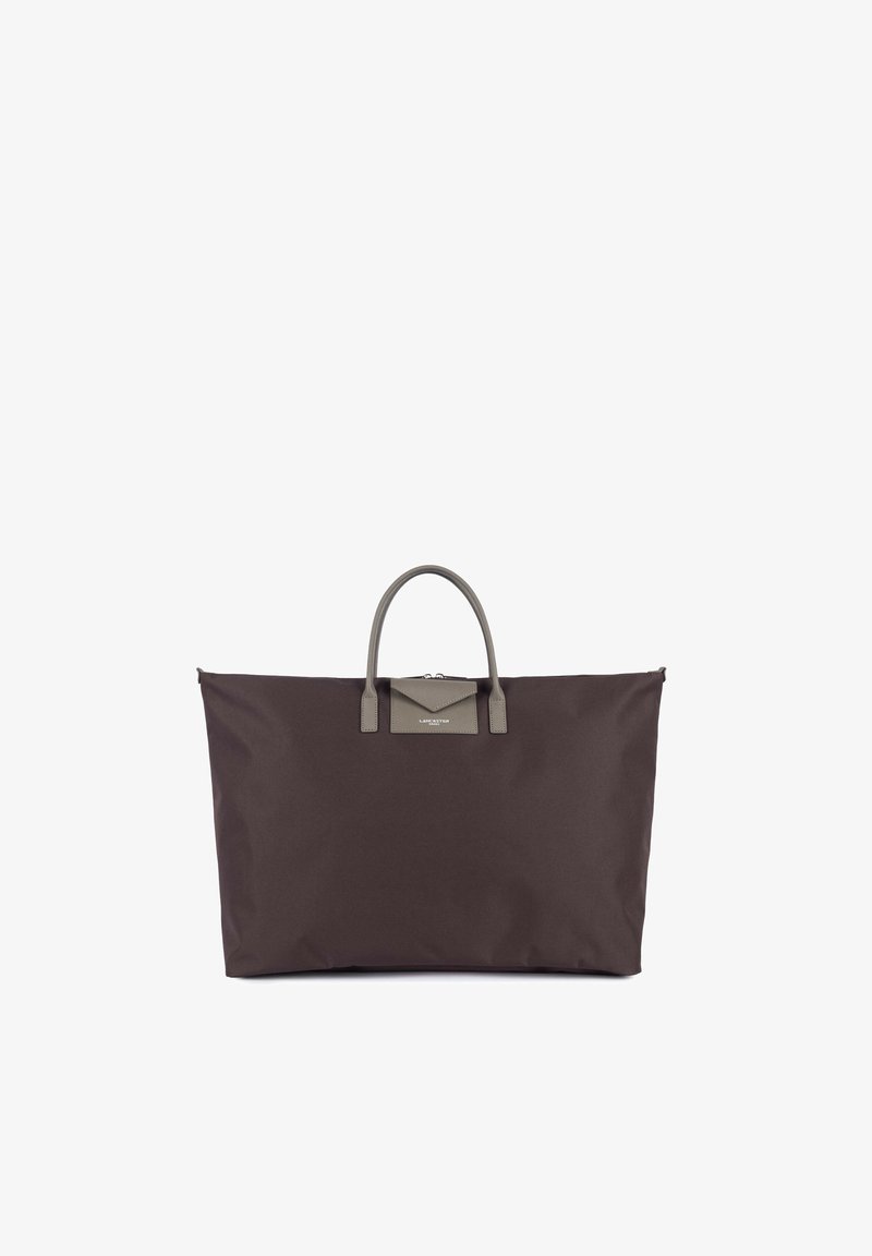 Grand sac de voyage brun foncé avec deux courtes poignées grises et une petite poche grise en forme d’enveloppe au centre avant.