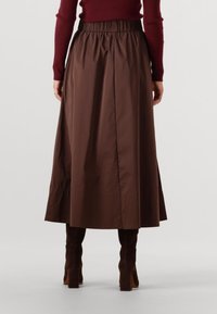 Bruine enkellange rok met een geplooide elastische tailleband, met een gladde, glanzende textuur en een rechte silhouet.