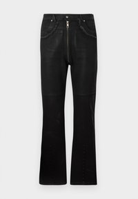 Crne trapezice od denima, s prednjim zatvaračem, teksturiranim džepovima s ispucalim rubovima, glatkom tkaninom i dugmadi na nogavicama.