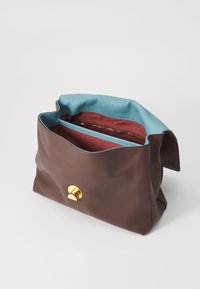 Borsa in pelle marrone con una finitura texture, dotata di un rivestimento azzurro chiaro e di un compartimento interno rosso. Presenta una chiusura con bottone in metallo dorato.