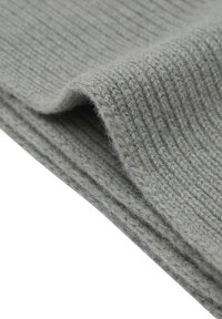 Lichtgrijze gebreide stof met een geribbelde textuur, met zachte vezels en subtiele tintvariaties. De stof heeft een lichte plooi.