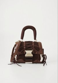 Sac à main marron et blanc avec une finition texturée, un motif en dentelle, une poignée tressée et des accessoires en argent. Forme compacte et structurée.