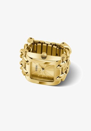 Montre-bracelet Guess ton or avec cadran carré, bracelet chaîne à maillons, et cadran minimaliste sans chiffres sur fond blanc.