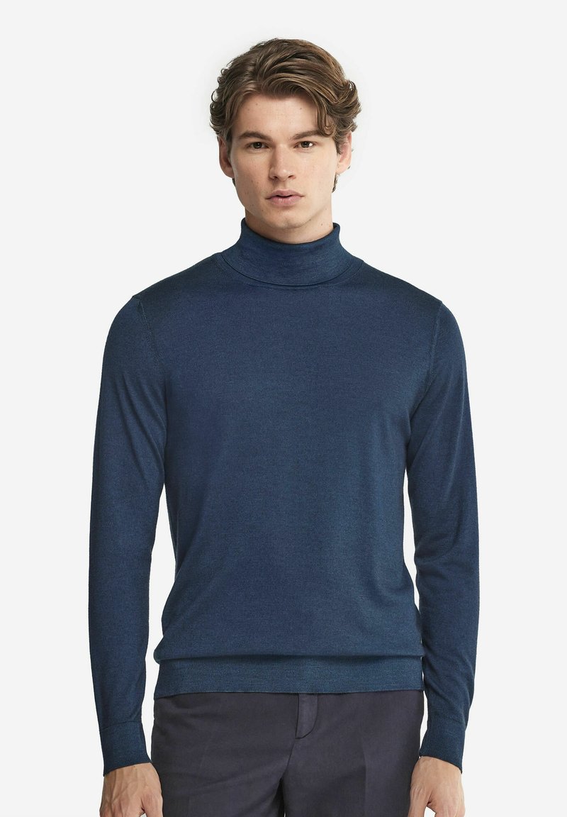 Mörkblå polotröja i slät stickad kvalitet. Har långa ärmar och en figurnära silhuett med ribbad fåll.