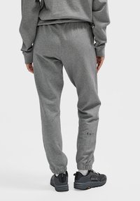 Graue Jogginghose aus einem weichen Baumwollmischgewebe, mit elastischen Bündchen, einem Kordelzugbund und gesticktem "F.U.T."-Logodetail.