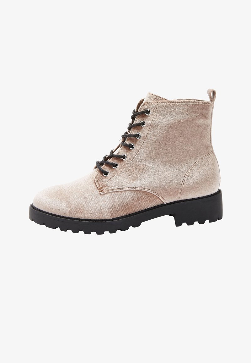 Bottine beige en velours à lacets avec semelle extérieure noire robuste et languette à l'arrière, vue de côté extérieur.