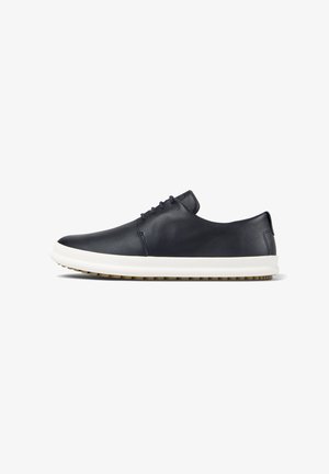 Navy leather sneakers with a smooth finish, white rubber sole, and contrasting beige outsole; features six eyelets and a rounded toe.