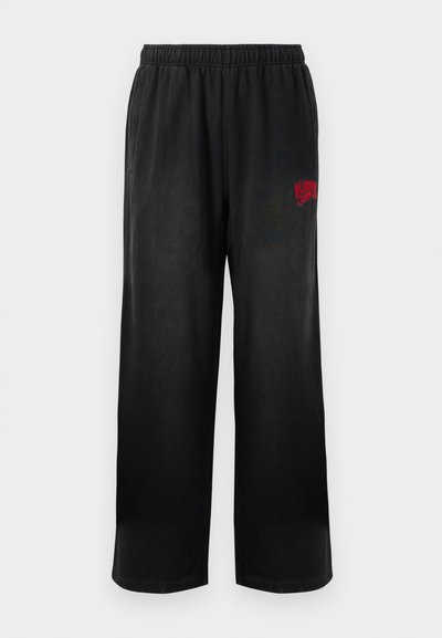 Pantaloni de trening negri cu elastic la talie și buzunare laterale. Prezintă logo-ul roșu "Billionaire Boys Club" pe coapsa dreaptă. Textură moale și netedă.