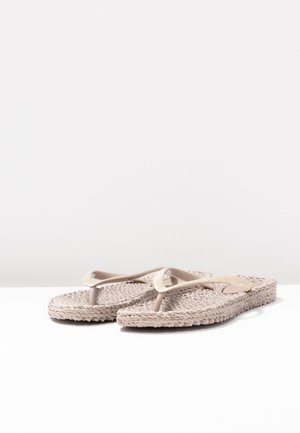 Pair of beige textured flip-flops with braided soles and glittery straps on a white surface against a plain background.