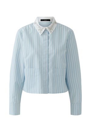 Hellblaue Bluse mit langen Ärmeln und vertikalen weißen Streifen, weißem spitzem Kragen mit Blumenstickerei und Fronttaschen.