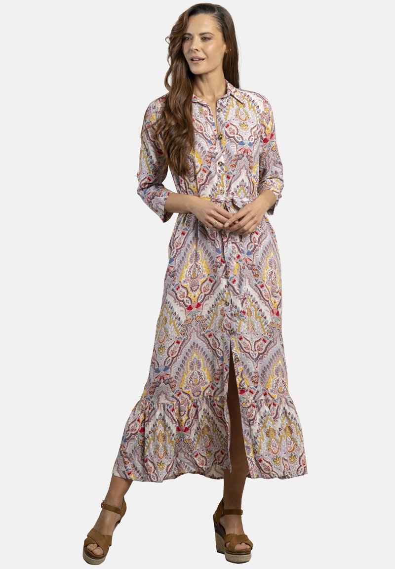 Vestido de manga larga y botones, con un patrón de cachemira multicolor; presenta un dobladillo acampanado y una abertura frontal, hecho de una tela ligera.