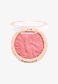 Blush compatto con una nuance di rosa morbido, texture liscia e motivo a onda, racchiuso in un astuccio circolare trasparente con base beige.