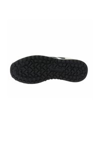 Suola in gomma nera con un motivo testurizzato caratterizzato da grip esagonali e a zigzag rialzati, progettata per trazione e durata.