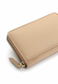 Portafoglio beige con zip realizzato in finta pelle testurizzata. Presenta dettagli in metallo dorato e un piccolo tirante, con un logo del marchio discreto sulla parte anteriore.