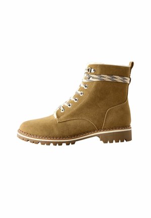 Botines de gamuza marrón claro con ojales de metal, puntera redonda, suela texturizada y acento decorativo de tela a rayas cerca de la parte superior.
