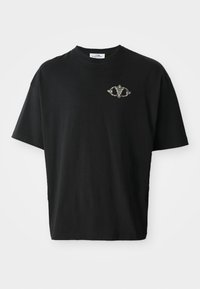 Black cotton t-shirt with a loose fit, featuring a small decorative design in gray on the chest. Short sleeves and crew neck.