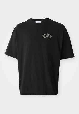 Schwarzes Baumwoll-T-Shirt mit lockerer Passform, das ein kleines dekoratives Design in Grau auf der Brust zeigt. Kurze Ärmel und Rundhalsausschnitt.