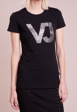 T-shirt noir en coton, avec un grand logo "VJ" étincelant en argent agrémenté de strass sur le devant. Manches courtes.