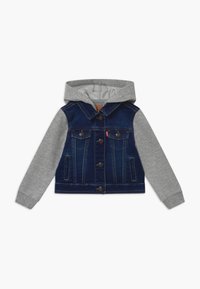 Children’s jacket with denim body, grey hood and sleeves, button front, and flap chest pockets on white background.