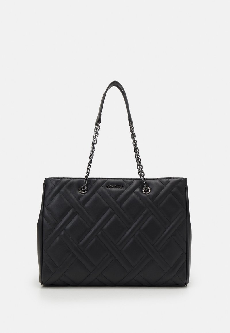 Sac à main en cuir noir matelassé avec chaîne et anses d’épaule en cuir, forme rectangulaire et logo discret de la marque sur le devant.