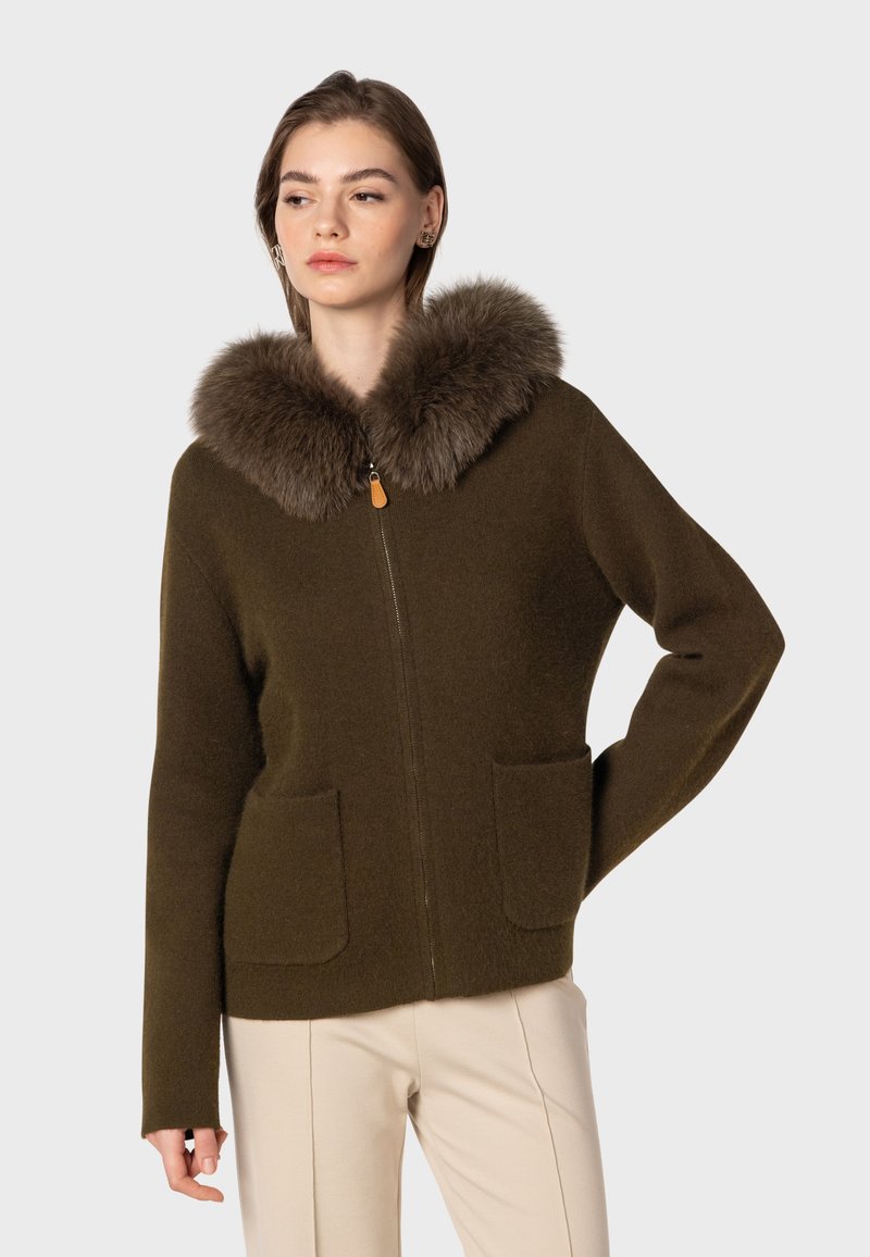 Brun zip-up jacka med pälskrage, med två framfickor och avslappnad passform. Mjuk textur och minimalistisk design.
