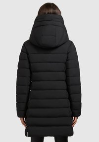 Mustra must coat kapuutsiga, millel on vertikaalsed õmblused, tihe istuvus ja veidi pikem äär. Sile kangas ilma nähtava brändita.