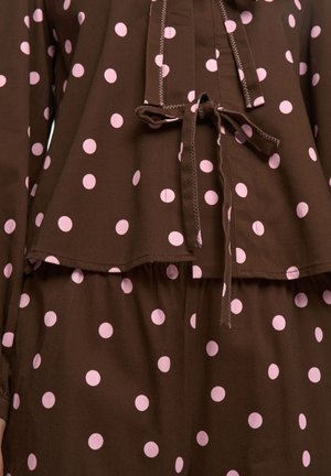 Brązowy strój w grochy z różowymi grochami, wiązaniem w talii, miękką fakturą i warstwowym krojem na górze i spodniach.